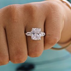 a close up of a person's hand with a ring on it and a diamond in the middle