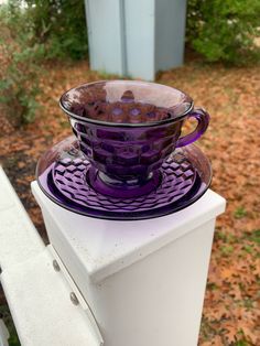 a purple glass bowl sitting on top of a refrigerator