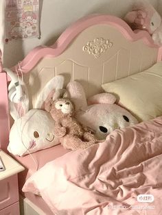 there are stuffed animals on the pink bed