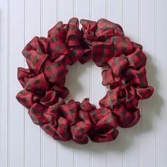 a red and black plaid christmas wreath on a white wall