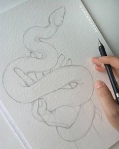 someone is drawing a snake on paper with a pencil