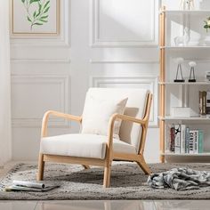 a white chair sitting on top of a rug next to a book shelf