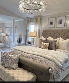 a large bed sitting in a bedroom under a chandelier