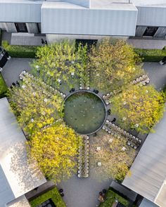 an aerial view of a circular garden in the middle of a building with trees surrounding it