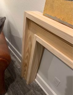 a brown leather chair sitting next to a wooden shelf