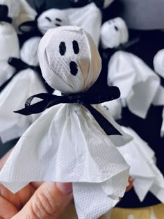 a hand holding a white cloth wrapped in black and white fabric with a ghost on it