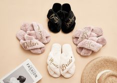 four pairs of personalized slippers and a straw hat on a pink surface with a book