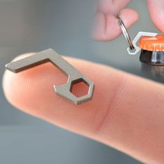 a tiny bottle opener being held by someone's finger with the word pico on it