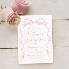 a pink rose is sitting next to a wedding card