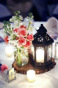 a vase with flowers and candles on a table