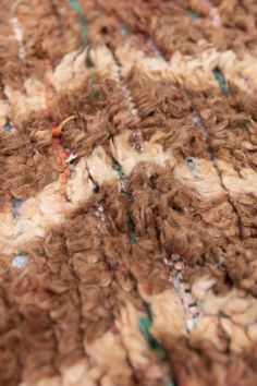 a close up view of some brown and white yarn on a bed sheet or blanket