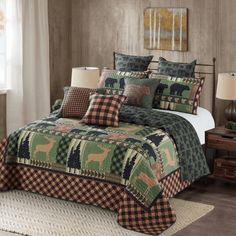 a bed covered in green and brown quilts with pillows on top of the bedspread