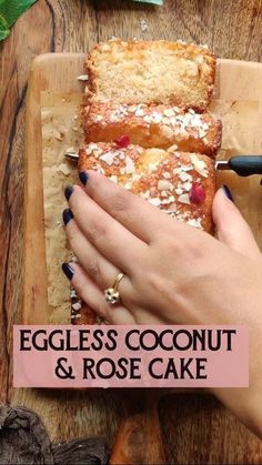 a close up of a person holding a piece of bread on a cutting board with the words eggless coconut and rose cake