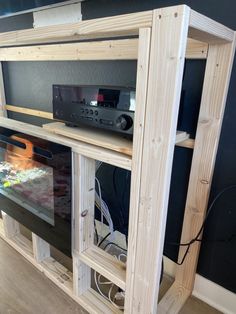 an entertainment center made out of plywood and wood with electronic equipment on the shelves