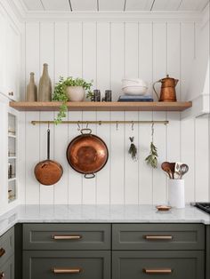 pots and pans are hanging on the wall in this kitchen