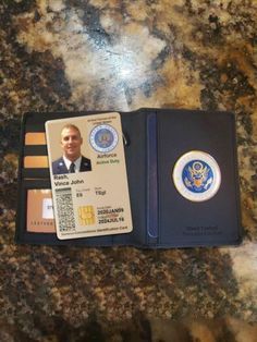 an id card and wallet sitting on top of a granite counter with a badge attached to it