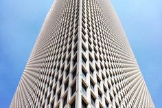 an upward view of the top of a building with blue sky in the back ground