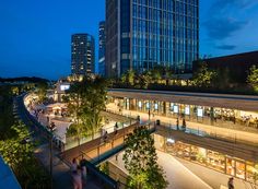 people are walking around in the city at night, with skyscrapers in the background