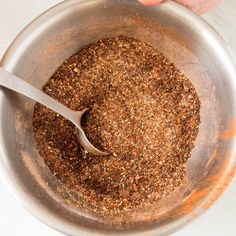 someone is stirring spices in a bowl with a spoon