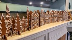 gingerbread houses are lined up on the mantle