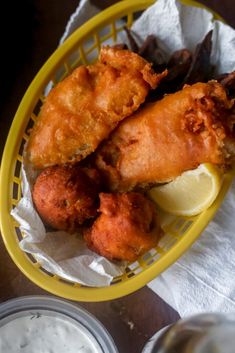 a basket filled with fried food next to some sauce