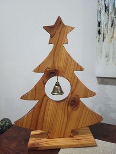 a wooden christmas tree with a bell on it