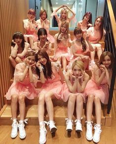 a group of young women sitting on top of a wooden step next to each other