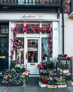 a store front with flowers on the windows