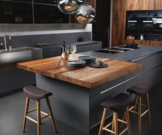 a kitchen island with two stools next to it and an oven in the background