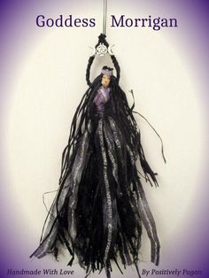 a doll hanging from a hook with the words goddess morgan on it's side