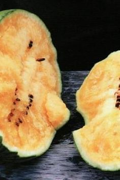 two pieces of melon sitting on top of a cutting board