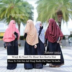 three women in hijabs are standing on the sidewalk with palm trees behind them