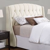 a bed with white headboard and pillows on top of it next to a night stand