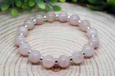 This sterling silver rose quartz crystal bead bracelet is handmade with 10mm genuine high-quality Madagascar rose quartz gemstones and sterling silver rondelle spacers. This crystal bead bracelet is 7.5 inches long and is made with thick elastic to ensure a comfortable fit and durability. It arrives in a jewelry gift box sprinkled with lavender and sage to cleanse the stones. The box is tied with a jute bow and accented with a handmade charm. A gemstone guide accompanies the crystal bead bracele Silver Rose Quartz Bracelet With 8mm Beads, Silver Crystal Bracelet With Rose Quartz Round Beads, Silver Rose Quartz Bracelet With Round Beads, Silver Rose Quartz Round Bracelets, Silver Rose Quartz Beaded Bracelets For Healing, Crystal Bead Bracelet, Quartz Gemstones, Wiccan Jewelry, Bracelet Heart