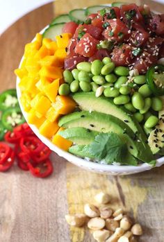 a bowl filled with lots of different types of food on top of a wooden table