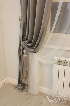 the curtains are pulled back and hanging on the side of the wall in front of the radiator