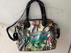 Pepino Leather offers to You: ANNA by Anuschka Hand Painted Leather Handbag Shoulder Bag in Excellent condition Done In The Design Titled "Magical Garden Fairy" A handcrafted original art piece that is actually hand-painted onto soft leather (not printed) to ensure each piece is pristine providing you with a luxury feel organizer for all your essentials 2 handles adjustable, removable shoulder strap with lobster clasp Unique piece signed by hand Logo pendant Floor reinforcement and supports Security compartment 2 side compartments Main compartment with zip Security compartment 2 pockets Cell phone compartment Key finder Width 42 cm Height 29 cm Depth 13 cm Before purchasing, please refer to the images for the exact mint condition of the item.  Fast, registered and insured shipping with tra Large Leather Handbags, Piece Sign, Garden Fairy, Hand Logo, Magical Garden, Hand Painted Leather, Leather Handbag, Fairy Garden, Lobster Clasp