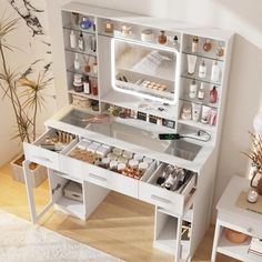 a white vanity with drawers, mirror and shelves filled with cosmetics on top of it