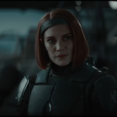 a woman with red hair in a sci - fi avatar suit looking at the camera