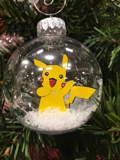 a glass ornament with a pikachu on it hanging from a christmas tree