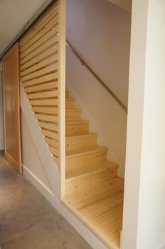 there is a wooden stair case next to the door