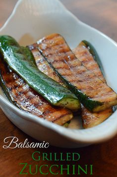 grilled zucchini in a white bowl on a wooden table