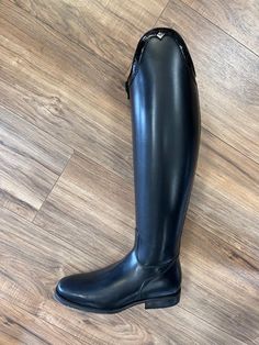 a pair of black boots sitting on top of a wooden floor