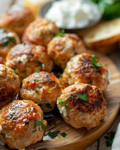 some meatballs are sitting on a wooden plate