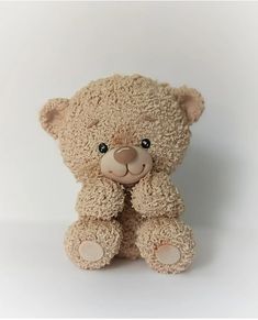 a brown teddy bear sitting up against a white background