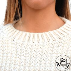 a close up shot of a woman's face wearing a white sweater and earrings