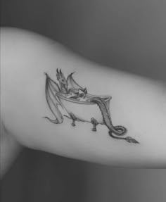 a black and white photo of a woman's arm with a dragon on it