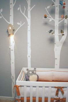 a baby crib with trees painted on the wall