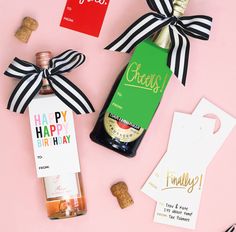 some wine bottles and tags on a pink surface