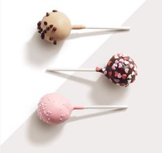 three cake pops with sprinkles on them are lined up next to each other